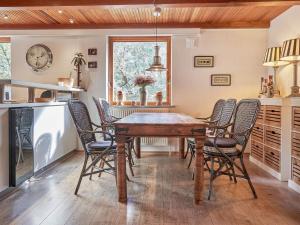 una sala da pranzo con tavolo e sedie in legno di 6 person holiday home in Nexø a Neksø