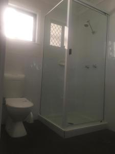 a bathroom with a toilet and a glass shower at Amble Inn in Warwick +14 photos