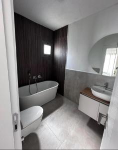 un bagno con vasca, WC e lavandino di Villa Novara a Milas Altre 12 foto