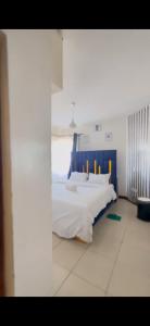a bedroom with a bed with a blue headboard at Madaraka 1 Westpointe in Nairobi