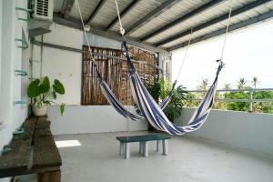 a porch with a hammock hanging from a ceiling at Dulan Tranquilo Hostel 台東都蘭晃輕鬆背包客棧 in Donghe