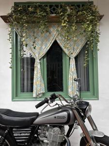 a motorcycle parked in front of a green window at Đà Lạt Homestay - Lối Nhỏ in Da Lat