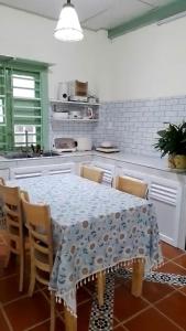 a kitchen with a table and chairs with a table and a tablecloth at Đà Lạt Homestay - Lối Nhỏ in Da Lat +13 photos