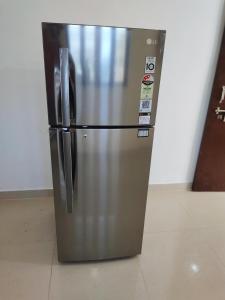 a stainless steel refrigerator sitting on a tile floor at ANAND BHAWAN Aj in Varanasi