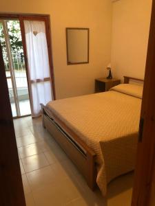 a bedroom with a bed and a sliding glass door at Casa vacanze un passo dal mare in Rodi Garganico