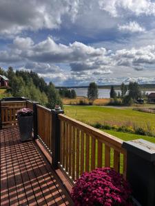 a deck with flowers and a view of the water at Hildas Hus with river view and spa in Särna +75 photos