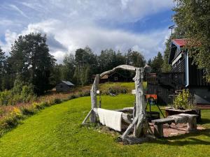 a wooden bench in a yard next to a house at Hildas Hus with river view and spa in Särna
