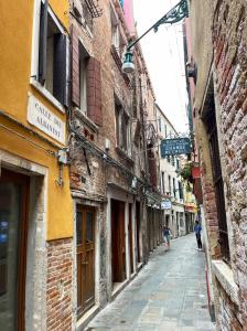 un callejón con edificios y una persona caminando por una calle en Ca Ducale 2 min da Piazza San Marco e Palazzo Ducale, en Venecia 41 fotos más
