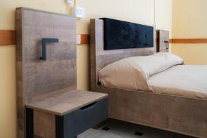 a bedroom with a bed with a wooden headboard at Santi Medici 2 in Grumo Appula
