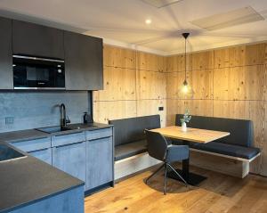a kitchen with a table and chairs and a dining room at Alpinum Chalet mit privater Außensauna in Rettenberg