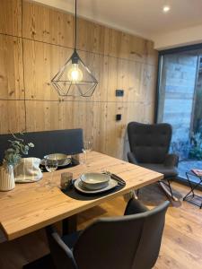 mesa de comedor con sillas y lámpara en Alpinum Chalet mit privater Außensauna, en Rettenberg
