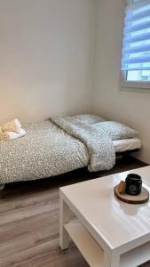 a bedroom with two beds and a coffee table at City Break Arras in Arras