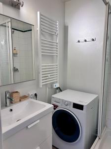 a white bathroom with a washing machine and a sink at City Break Arras in Arras