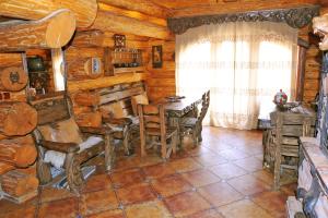 ウージュホロドにあるVedmezha Berlogaのログキャビン内のテーブルと椅子が備わる客室です。
