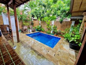 a swimming pool in a backyard with a fence at Is Oke House in Gili Trawangan