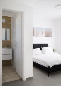 a white bedroom with a bed and a bathroom at 3BR charming on the 14th floor overlooking the sea in Qiryat Yam +6 photos