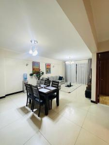 a living room with a table and chairs and a couch at Skyhorse condo in Nairobi