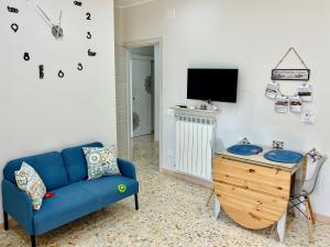 Una sala de estar con un sofá azul y una mesa. en Pink Fox - Family Apartment -, en Portici