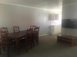 a dining room with a table and chairs and a television at Amble Inn in Warwick