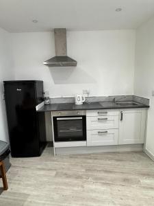 a kitchen with a black refrigerator and a stove at City Centre Flat in Southampton