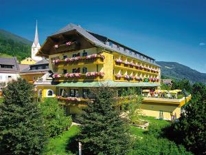 un gran edificio amarillo con flores en los balcones en Hotel & Restaurant Wastlwirt, en Sankt Michael im Lungau