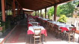 an outdoor restaurant with tables and chairs with red napkins at Hotel La Pineta in Spilinga