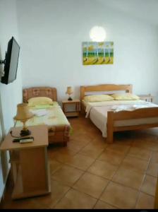 a bedroom with two beds and a table with a tv at Montenegrina in Budva