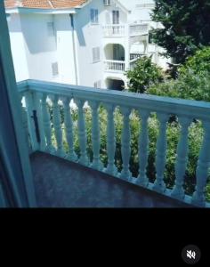 a balcony with a white railing in front of a building at Montenegrina in Budva
