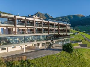 an external view of a building with mountains in the background at Hotel Purvita - Ski In Ski Out - Infinity Pool in Maranza