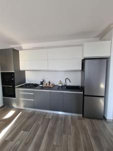 a kitchen with stainless steel appliances and wooden floors at CityView Apartment in Arad +3 photos