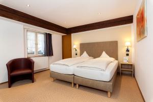 a bedroom with a large bed and a chair at Romantik Hotel Johanniter-Kreuz in Überlingen