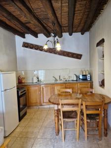 a kitchen with a table and chairs and a refrigerator at John' s House in Omodos in Omodos