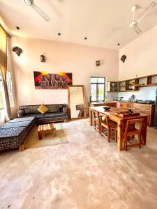 a large living room with a table and a kitchen at Alcyone Residence - Ocean View Villa in Muyuni