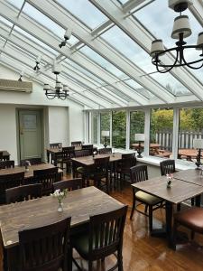 a dining room with tables and chairs and windows at Feildens Arms Hotel in Blackburn