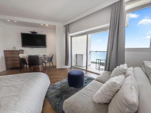a living room with a couch and a large window at The Sharon Sunset Loft in Herzliya B