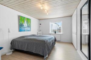 a bedroom with a bed in a room with white walls at 70372-Ulfborg-Skolegade-6 in Thorsminde