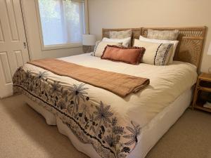 a bedroom with a large bed with a blanket on it at Budgaribah in Old Bar