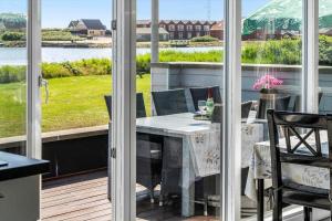 a dining table on a balcony with a view of the water at 70372-Ulfborg-Skolegade-6 in Thorsminde