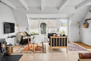 una sala de estar con un sofá y una chimenea en 20045-Ulfborg-Hummelmosevej-5, en Sundhuse