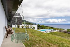 a swing on a house with a view of the ocean at Grande Mar Villa in Ponta Garça