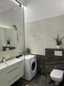 a bathroom with a washing machine and a sink at Stylische Ferienwohnung in Salzburg +15 photos