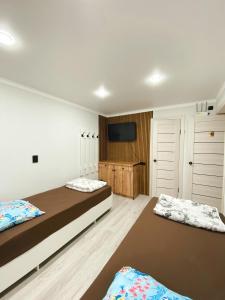 ウラリスクにあるQaragai hostelのベッド2台と薄型テレビ付きのベッドルーム