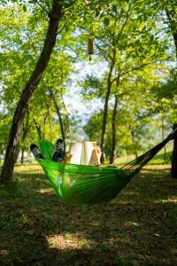 a green hammock with a book in a park at Tra Emilia e Toscana - Country Retreat & Outdoor in Toano