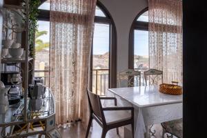 a dining room with a table and two large windows at Vivienda Vacacional TINIZARA in Arona