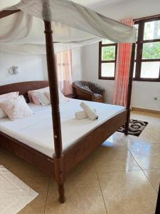 una cama con dosel en una habitación en Private 3 Bedroom Villa - Diani, en Ukunda 14 fotos más