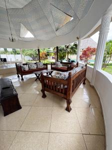 una sala de estar con sofás y mesas en un porche en Private 3 Bedroom Villa - Diani, en Ukunda