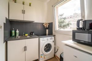 a kitchen with a sink and a washing machine at Proche centre et calme - cozy - parking privé en résidence in Colmar