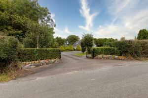 a road leading to a house with bushes and flowers at Fernfeild in Old Twopothouse Cross Roads