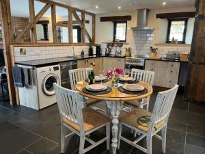 a kitchen with a table and chairs and a kitchen with a stove at The Stable at Widemouth Bay - 2 bedroom cottage both rooms twin or king in Poundstock