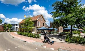 ルーネンにあるDen Eikenboomのスクーターに乗る男